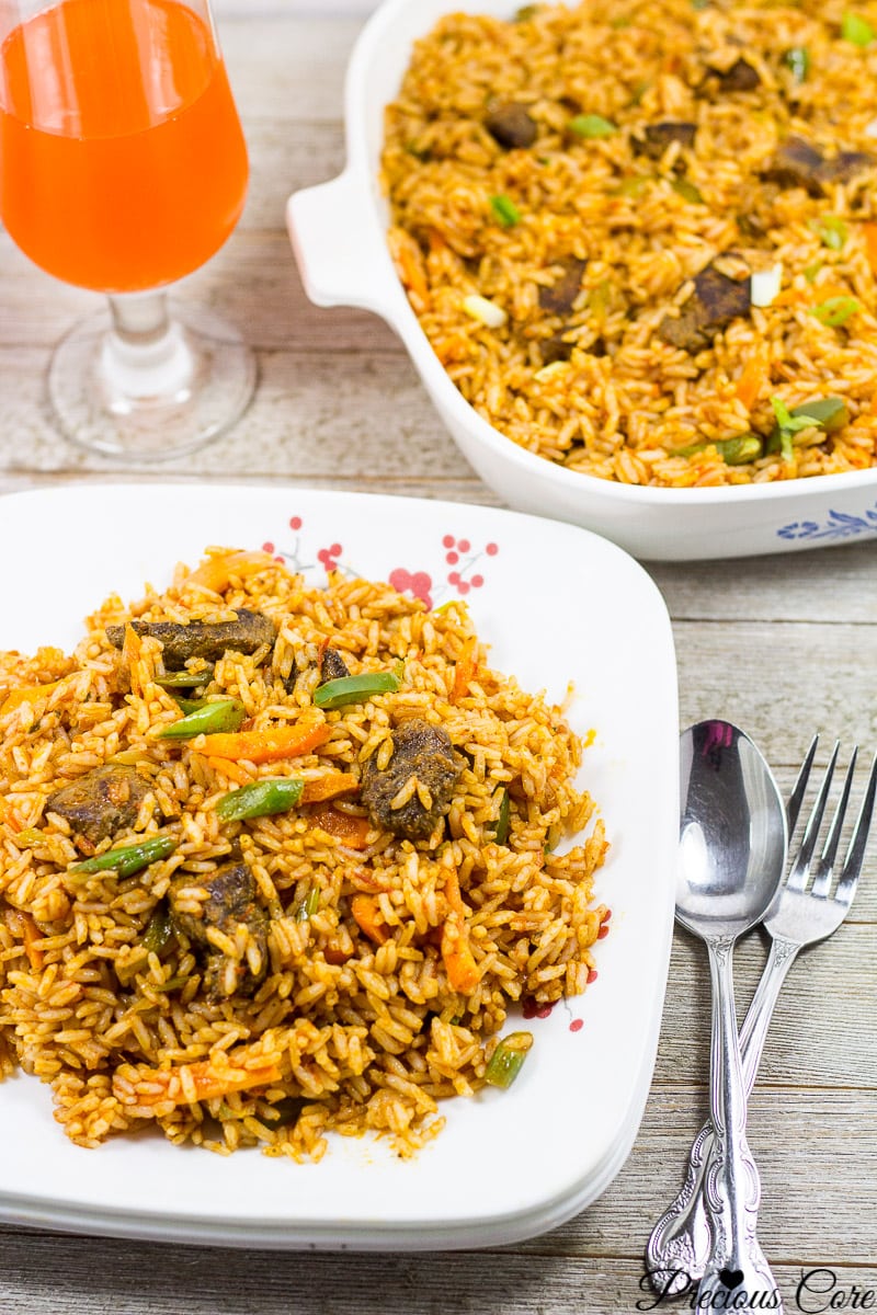 Jollof Rice on a plate with cutlery nearby.