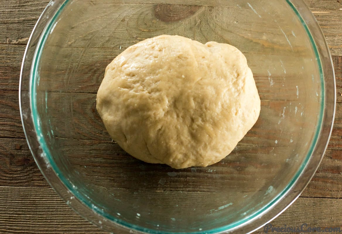 Sweet dinner roll dough in a glass bowl.
