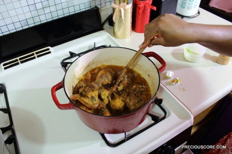 Person stirring a Dutch oven of chicken.