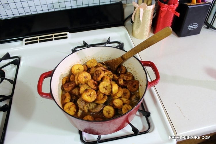 Plantains in a red Dutch oven with chicken.