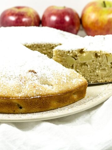 Apple cake with a slice being removed.