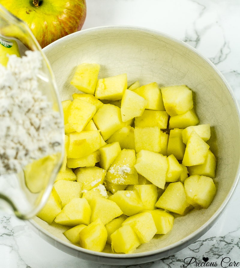 Adding flour to apple chunks.