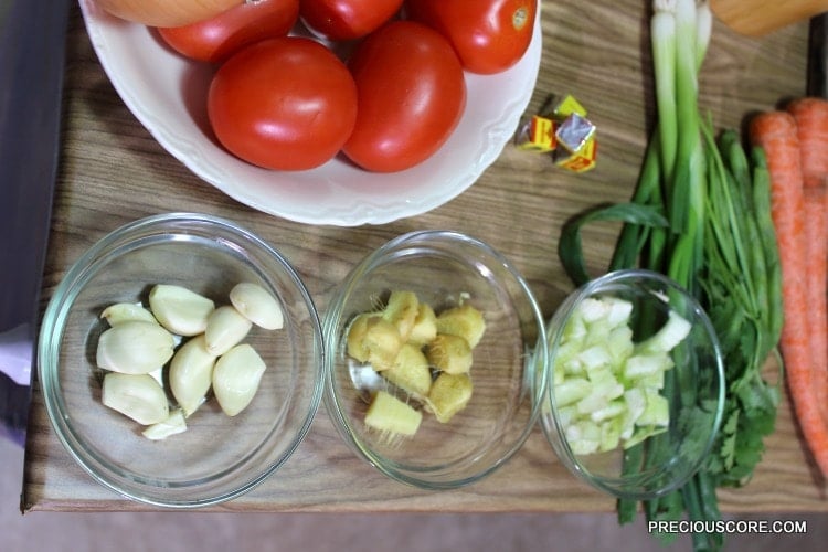Bowls of ingredients including tomatoes, garlic, and ginger.