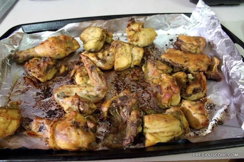 Oven grilled chicken in a lined baking dish.