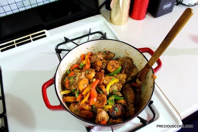 Wooden spoon in a Dutch oven of poulet DG.