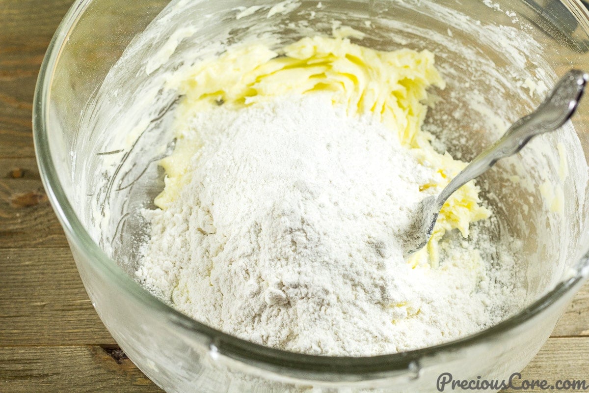 Adding flour to butter and sugar.