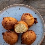 Coconut doughnuts on a plate with one opened up