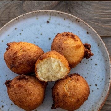 Coconut doughnuts on a plate with one opened up