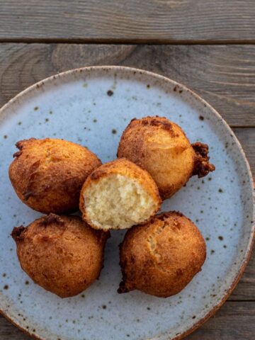 Coconut doughnuts on a plate with one opened up
