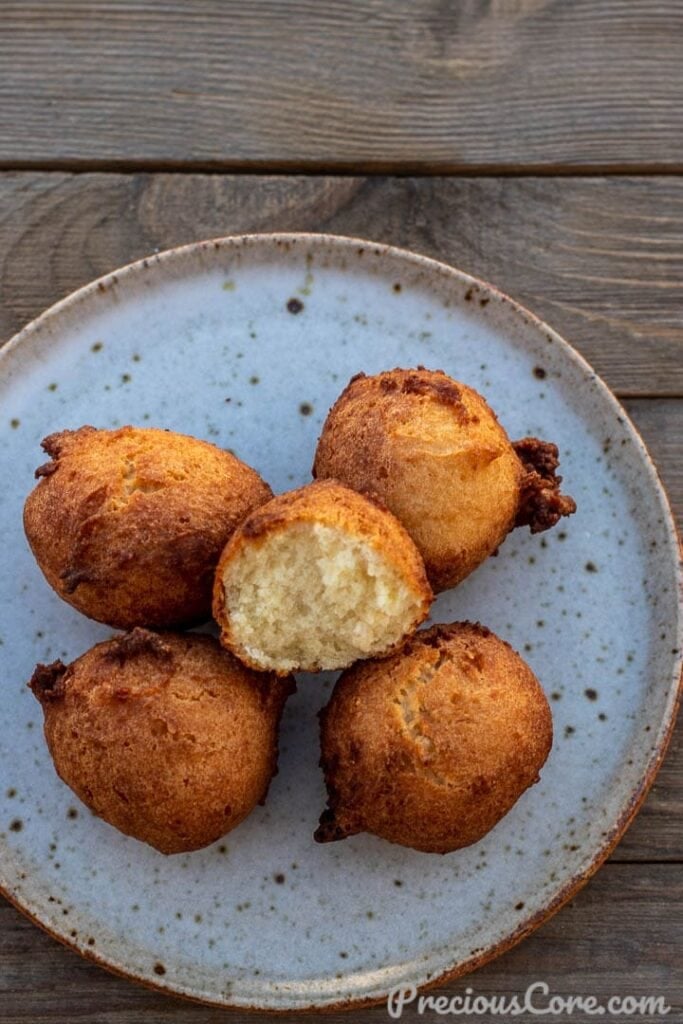 Coconut doughnuts on a plate with one opened up