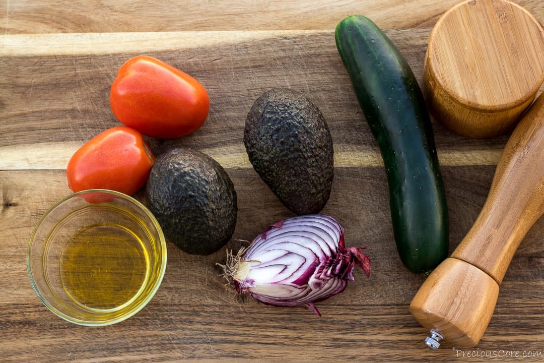 Avocado salad ingredients - avocado, cucumber, tomatoes, onion, black pepper, salt, olive oil