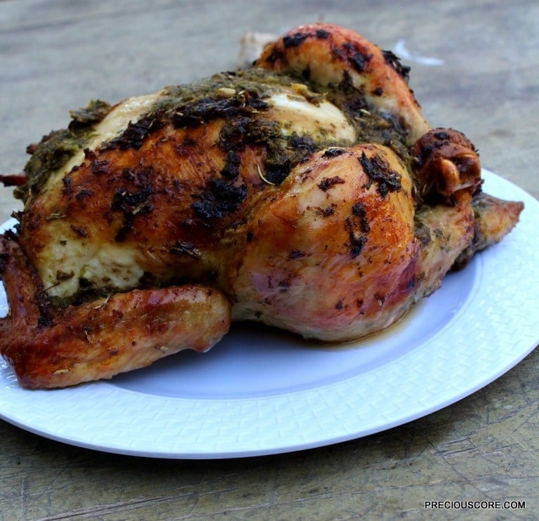 Whole roast chicken on a white plate.