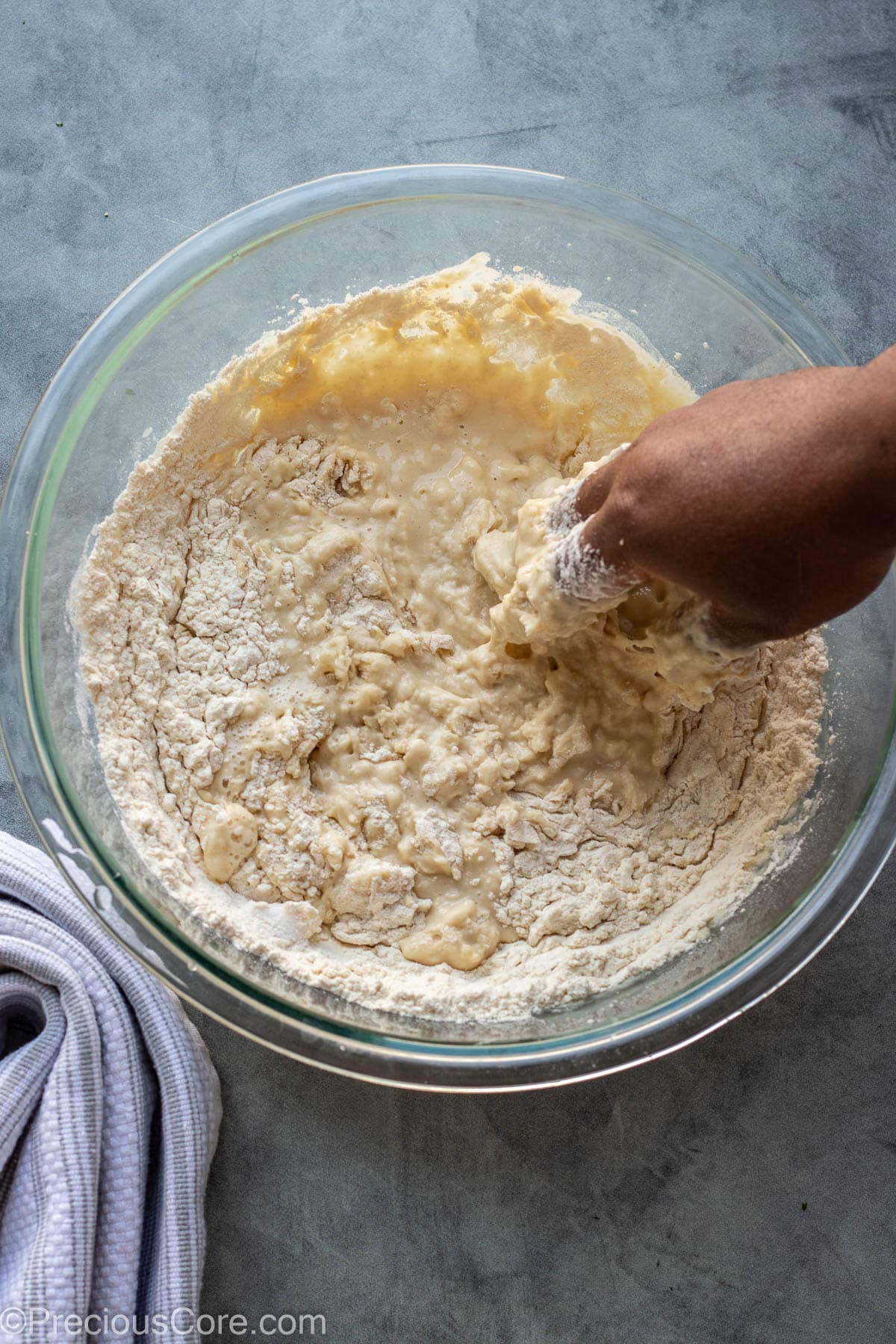 Hand mixing Puff Puff in bowl.