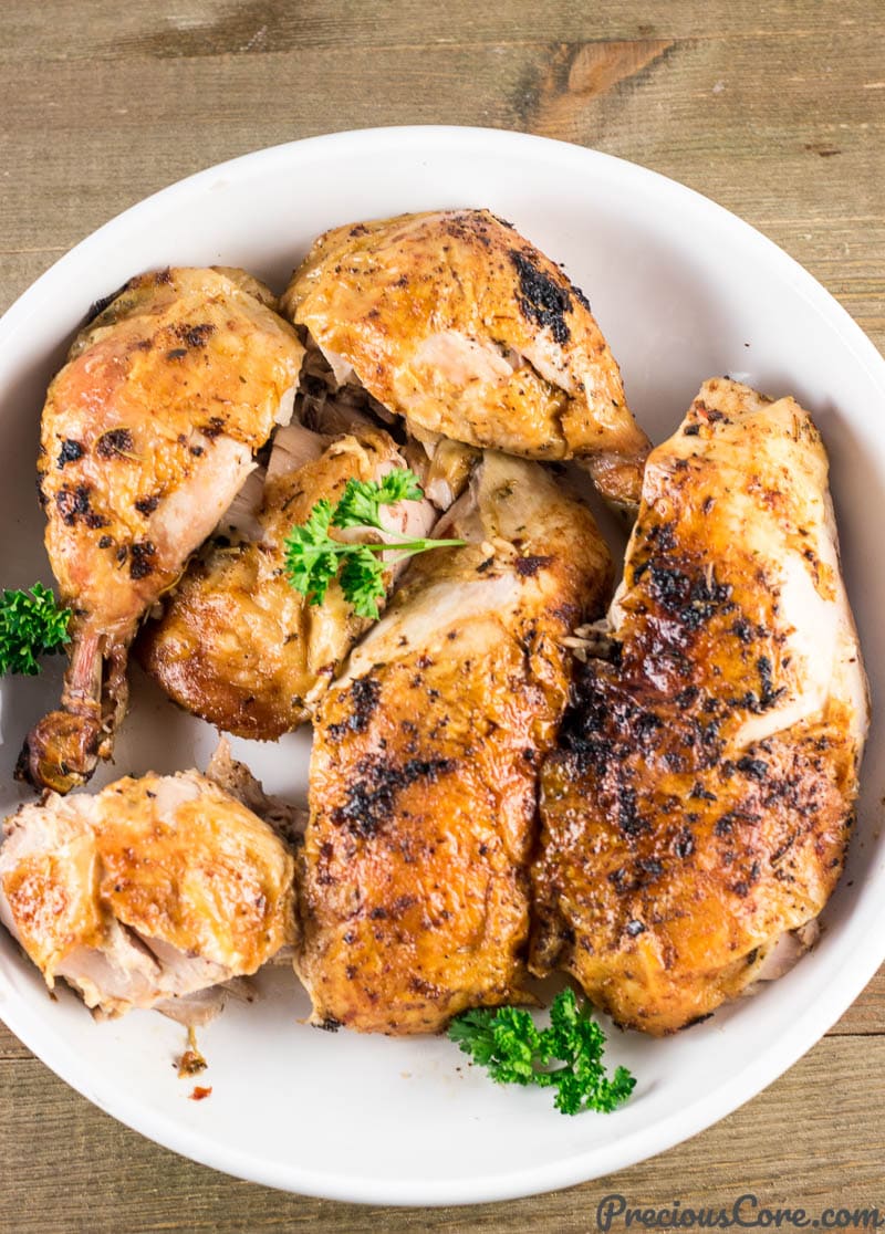 Carved whole chicken on a white platter.