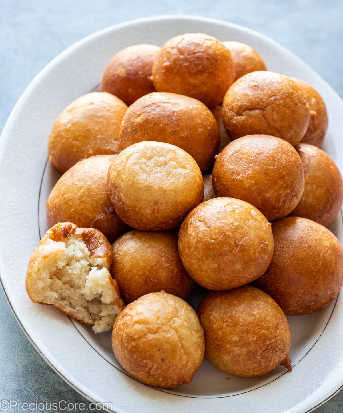 Puff Puff on a tray with one cut to show texture.