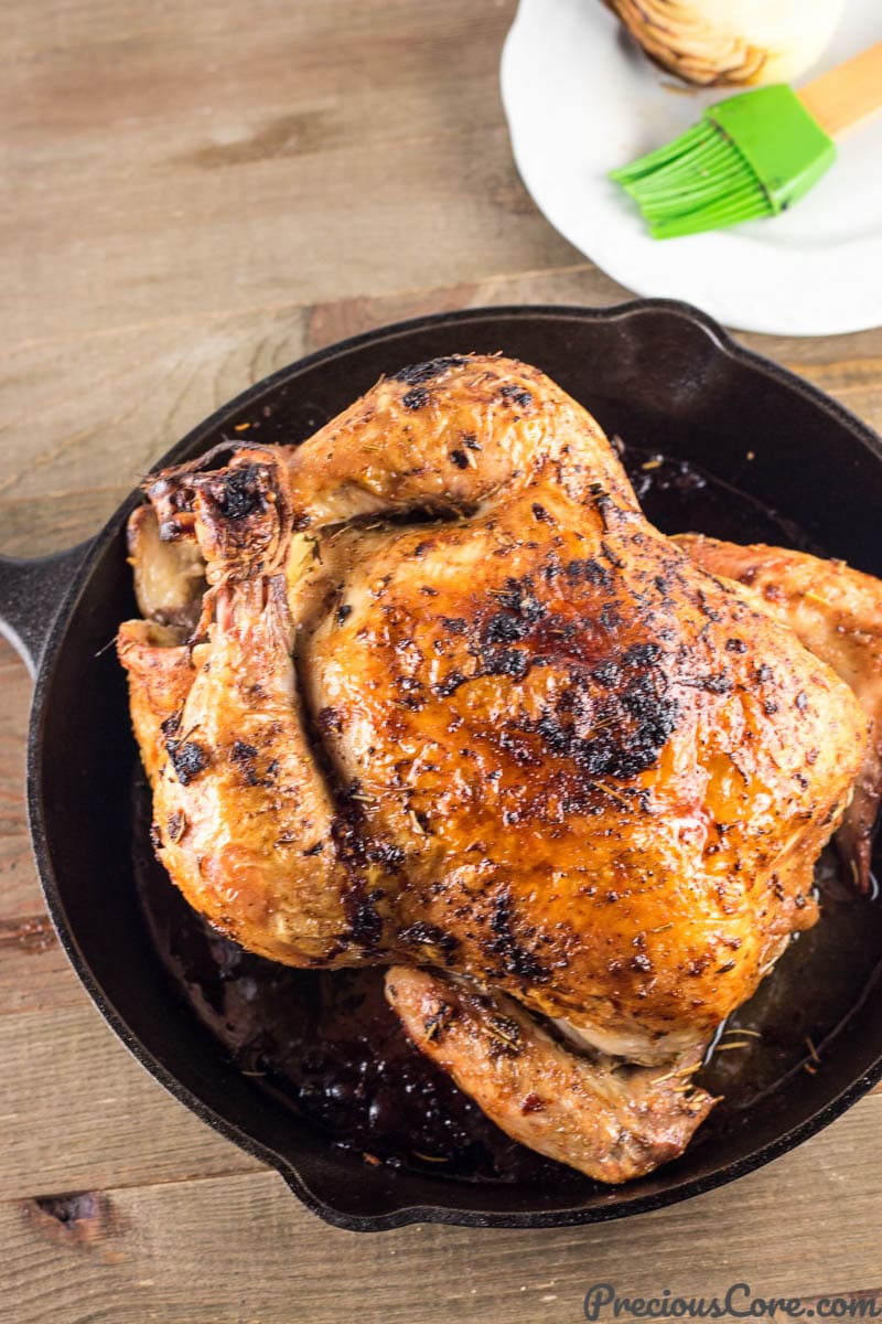 A whole roasted chicken in a cast iron skillet.