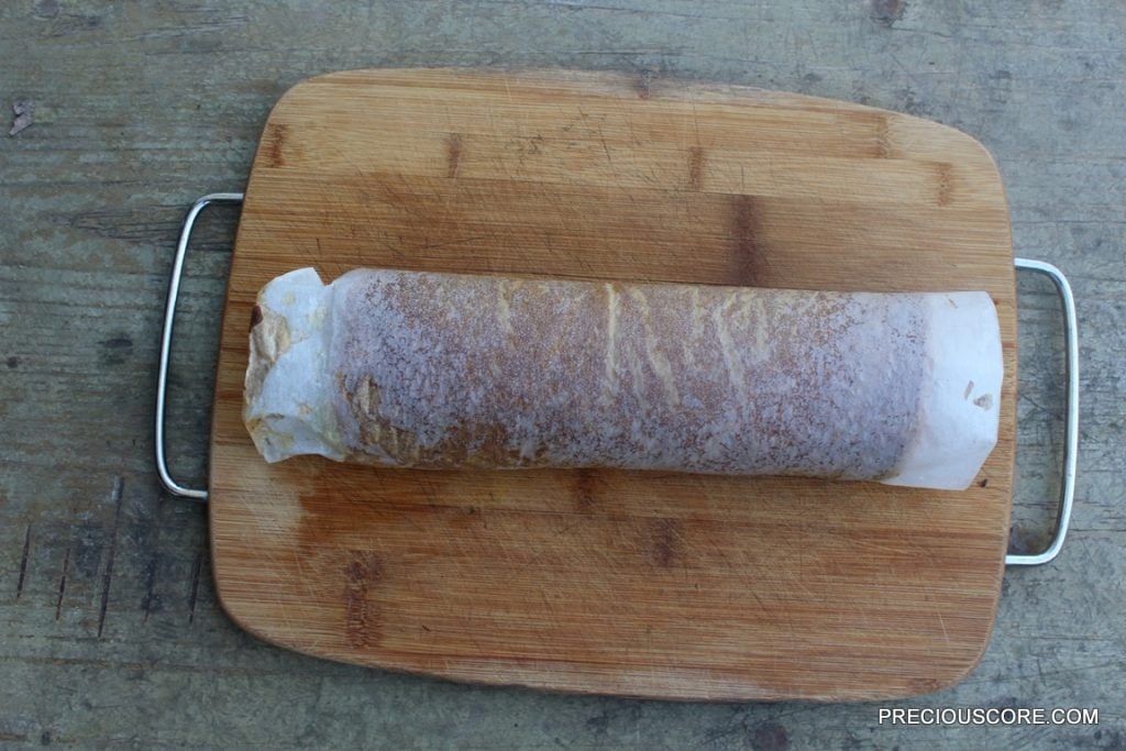 Pumpkin cake rolled on a cutting board.