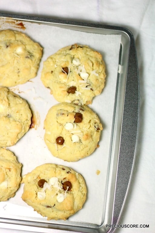 Coconut chocolate chip cookies on a lined baking sheet.