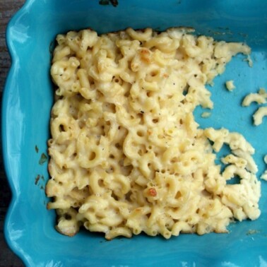 Blue dish of partially-served macaroni and cheese.