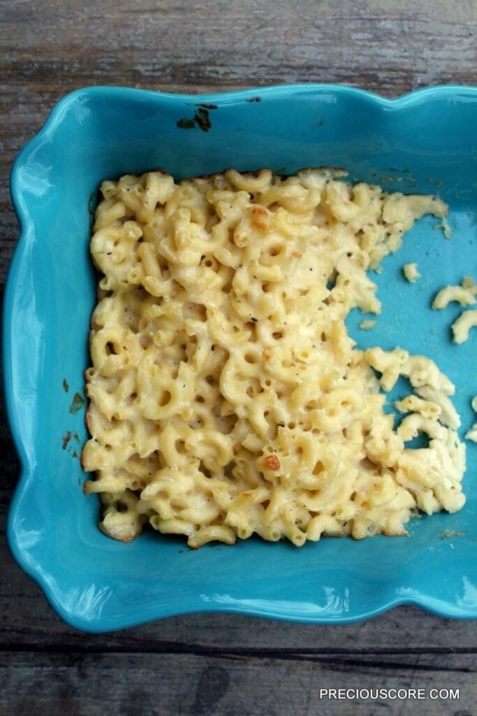 Blue dish of partially-served macaroni and cheese with Stella parmesan.