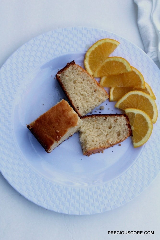 Slices of yogurt cake on a plate with orange slices.