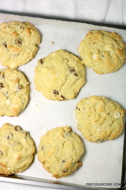 Coconut chocolate chip cookies on a lined baking sheet.