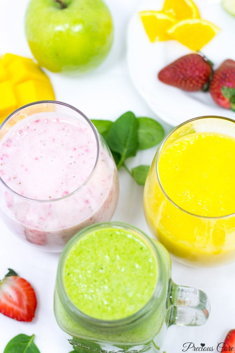 Three differently-colored smoothies in small glasses.