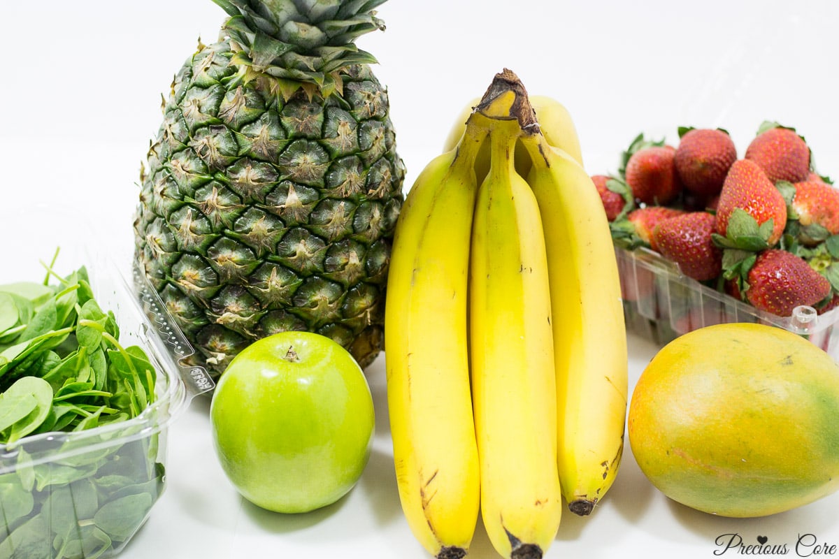 Fruits on a counter, including pineapple, banana, and strawberry.