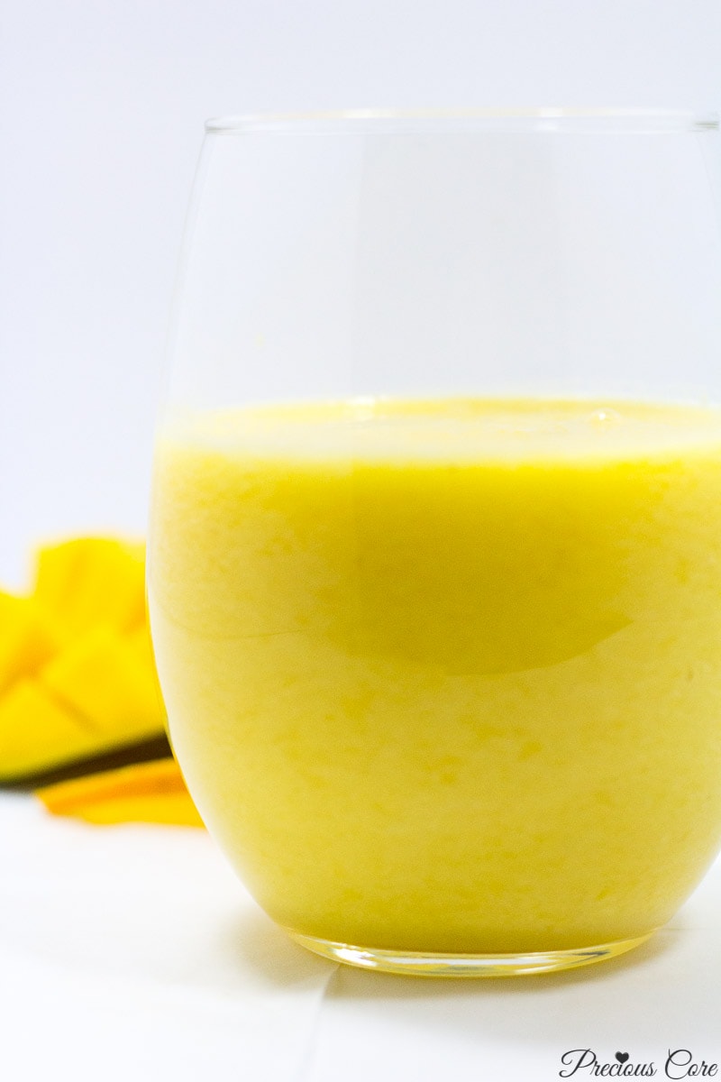 Pineapple mango smoothie in a small glass.