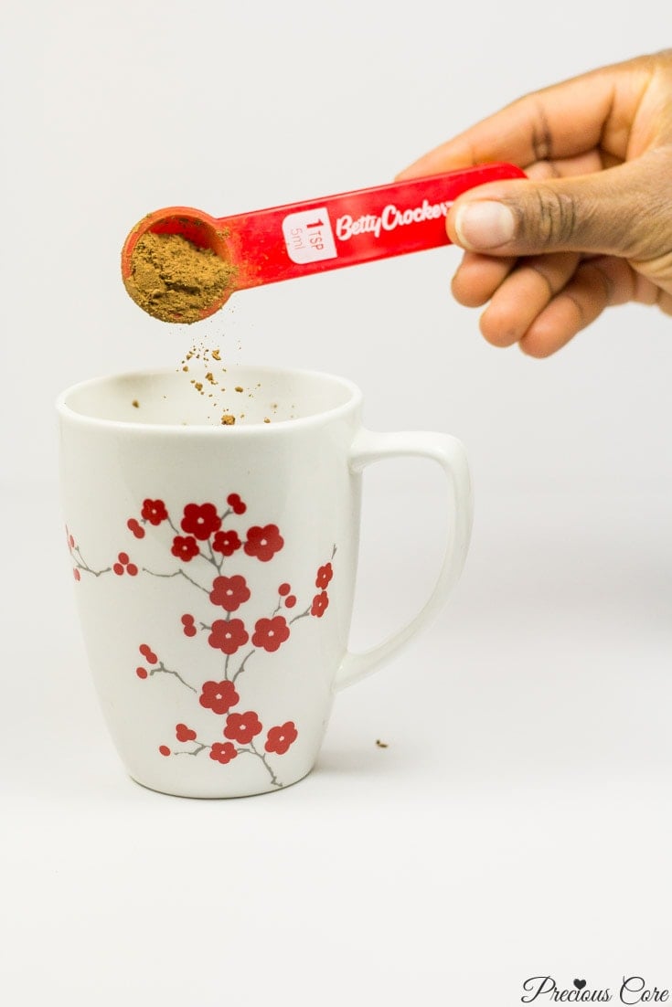 Cocoa powder pouring into a floral mug.