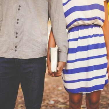 A couple holding hands and a Bible.