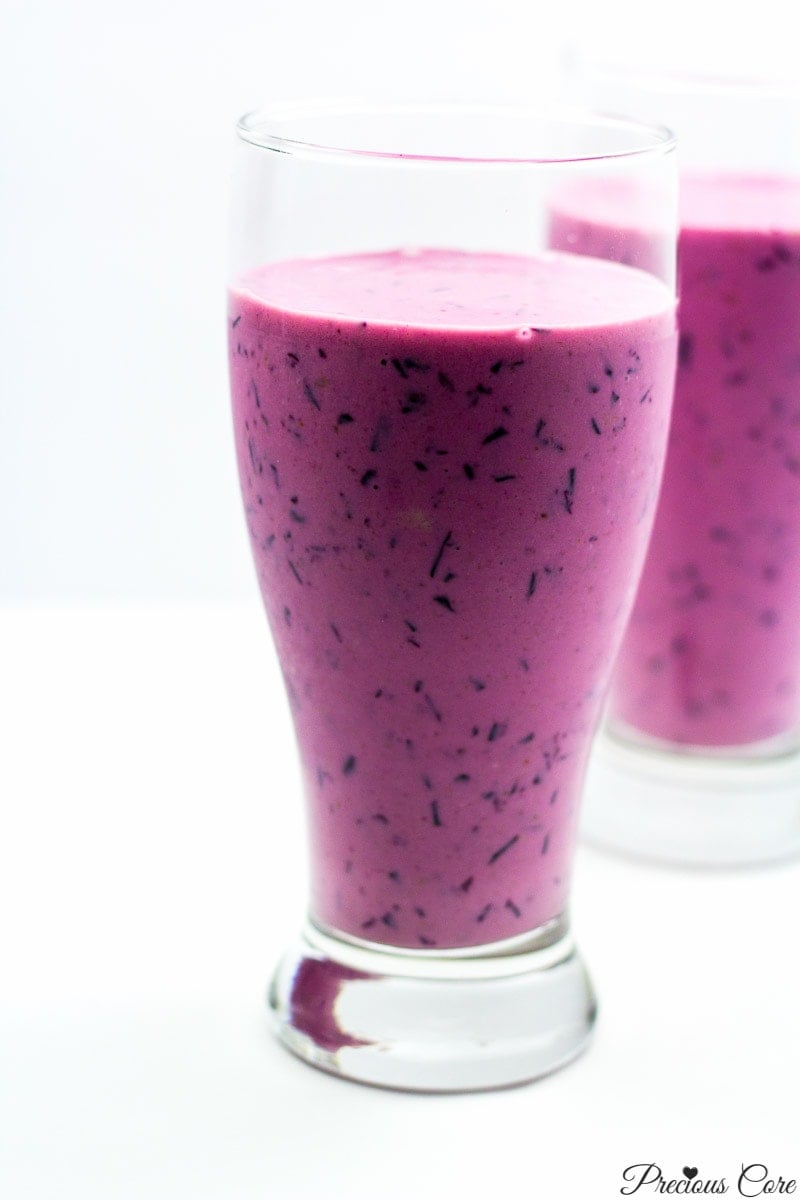 Two tall glasses of purple smoothie.