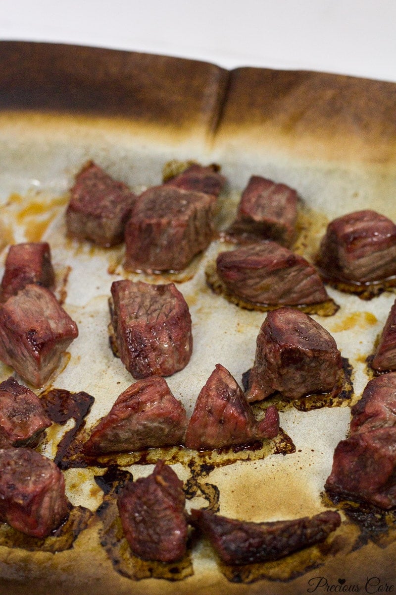 Cooked meat on a lined baking sheet.