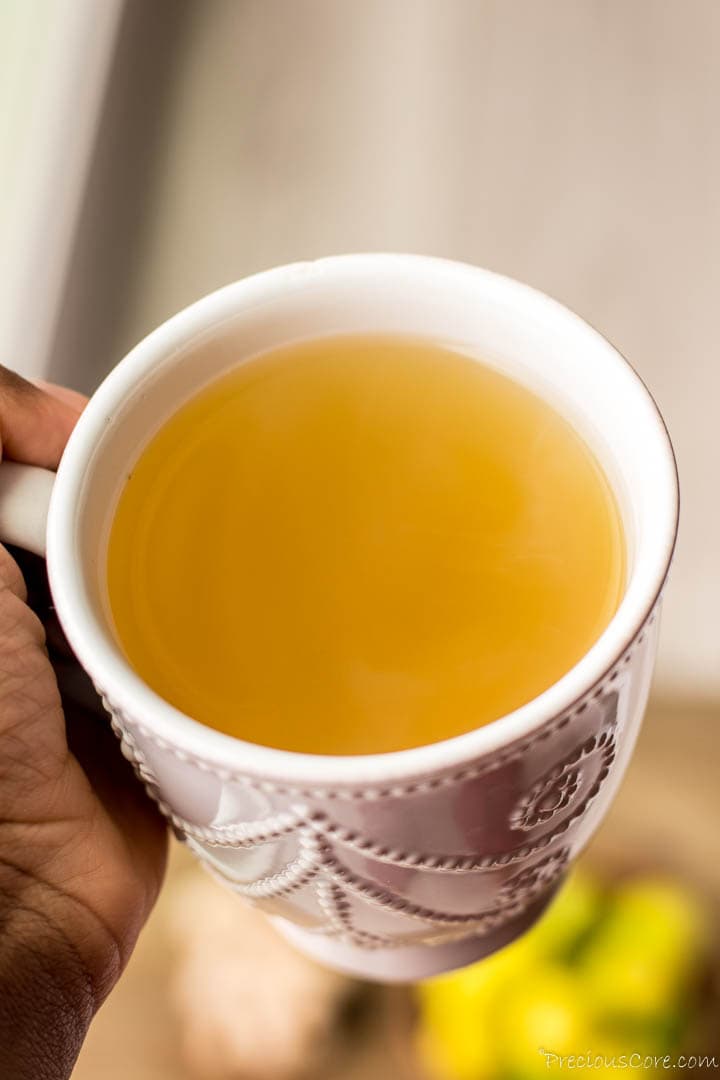 Hand holding a mug of ginger tea