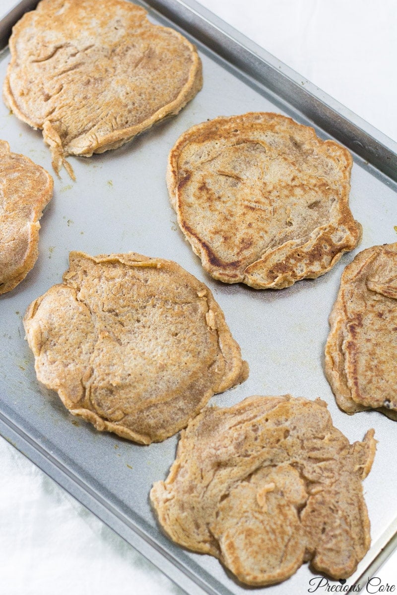 Eggless pancakes on a lined baking sheet.