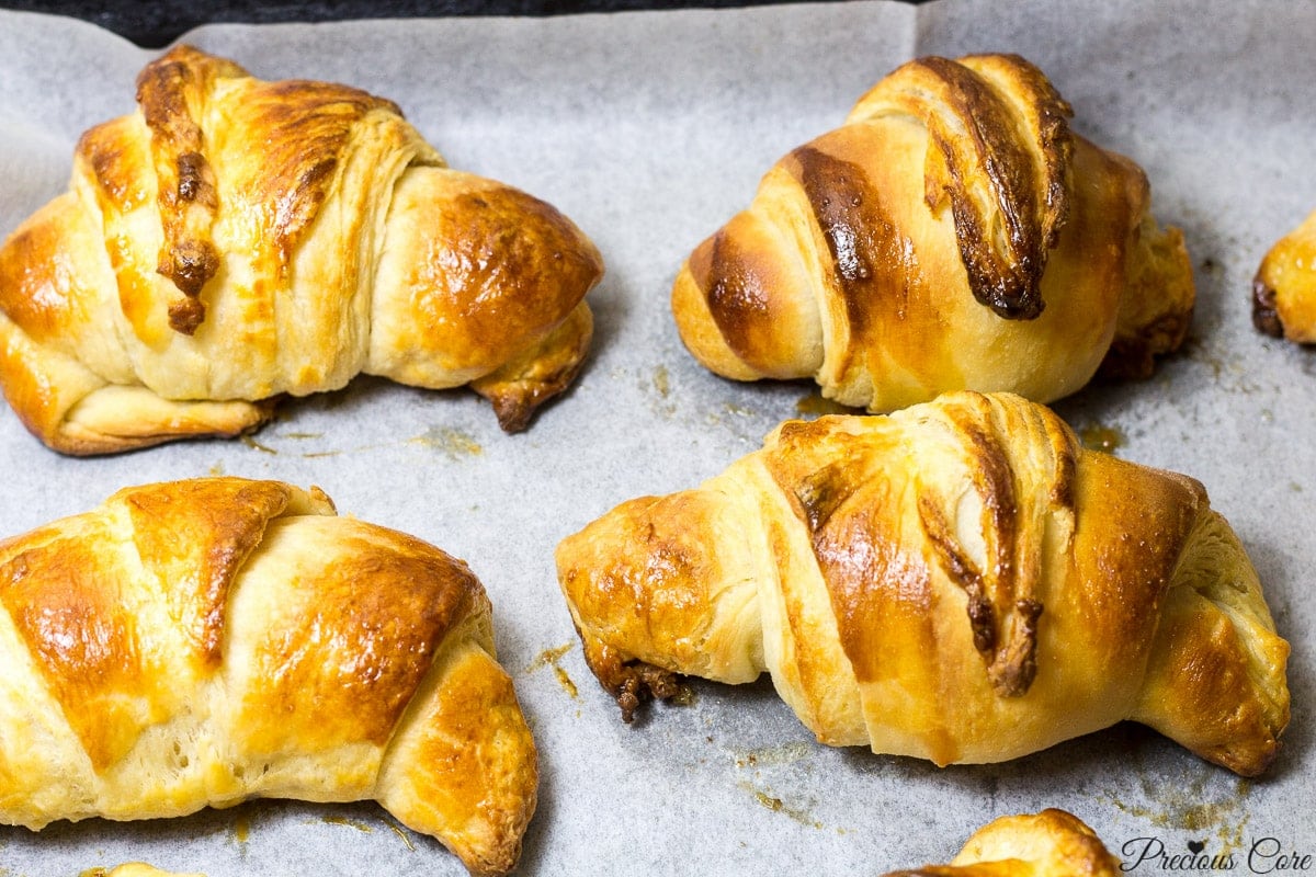 Homemade croissants on parchment paper.