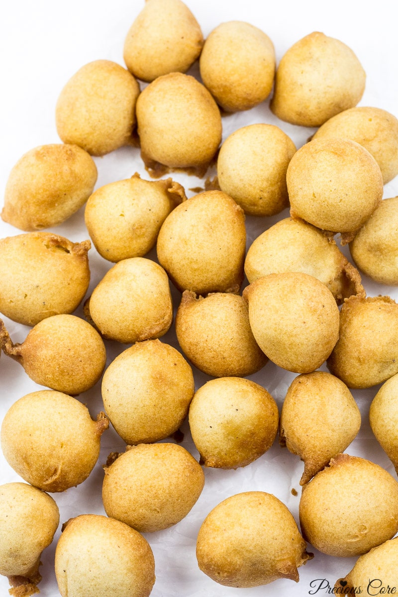  Cameroonian drop doughnuts on white parchment paper.