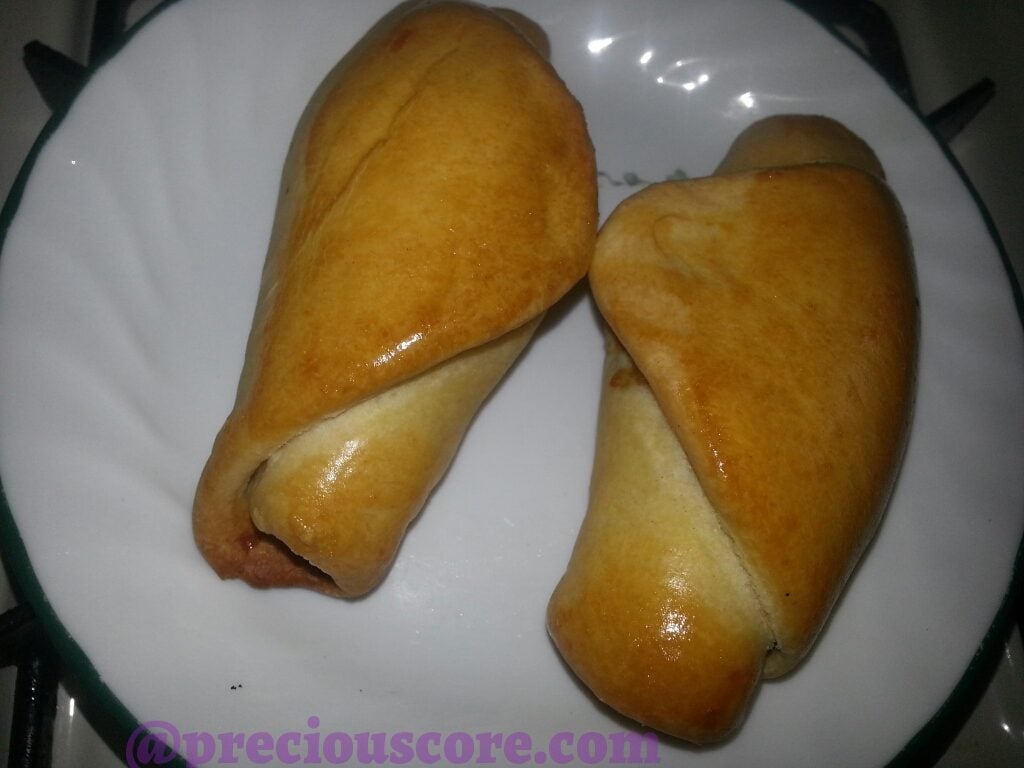 Two chicken rolls on a white plate.