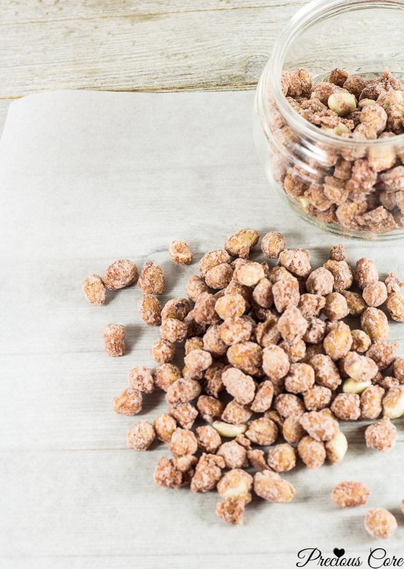 Candied nuts in and around a glass jar.