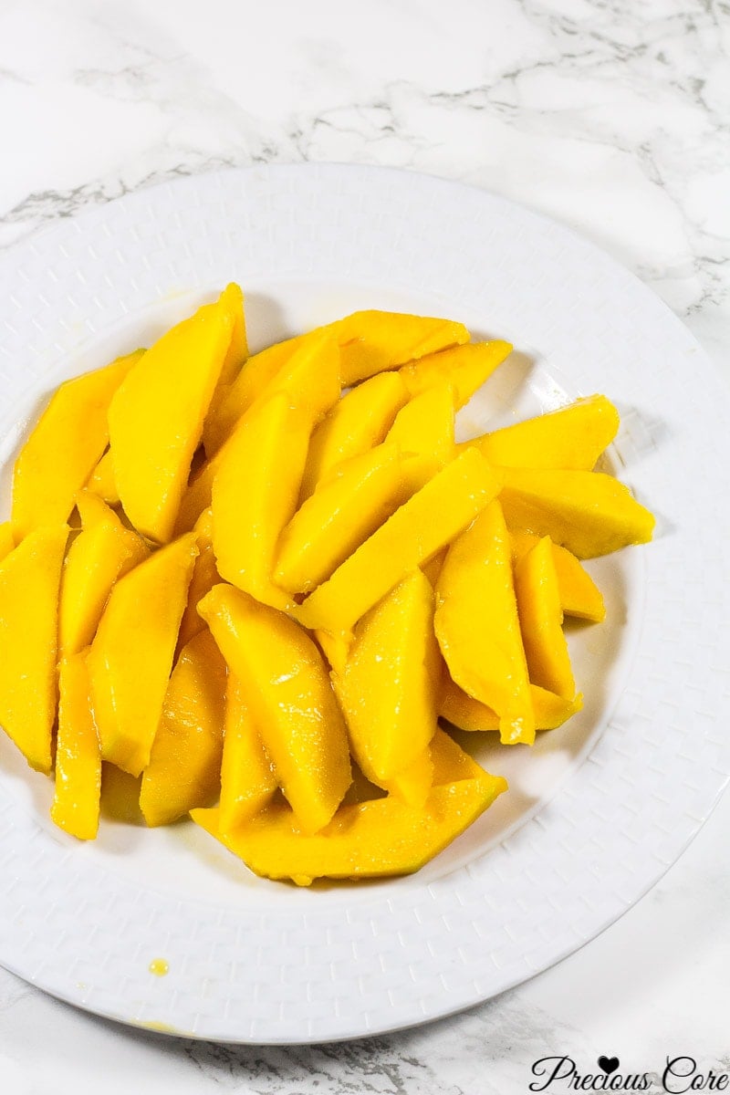 Sliced mango on a white plate.