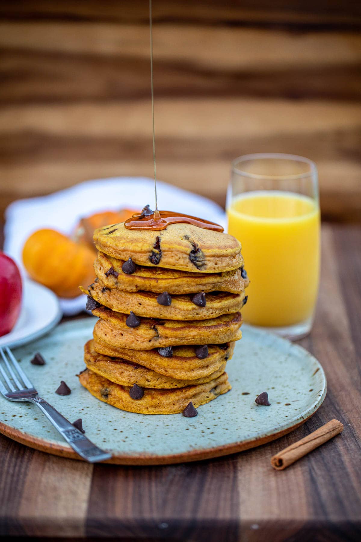 Stack of pancakes with honey drizzling on top.