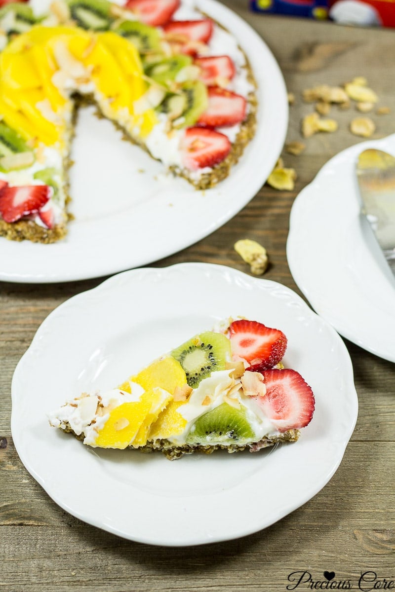 Slice of breakfast pizza with cereal crust on a white plate.