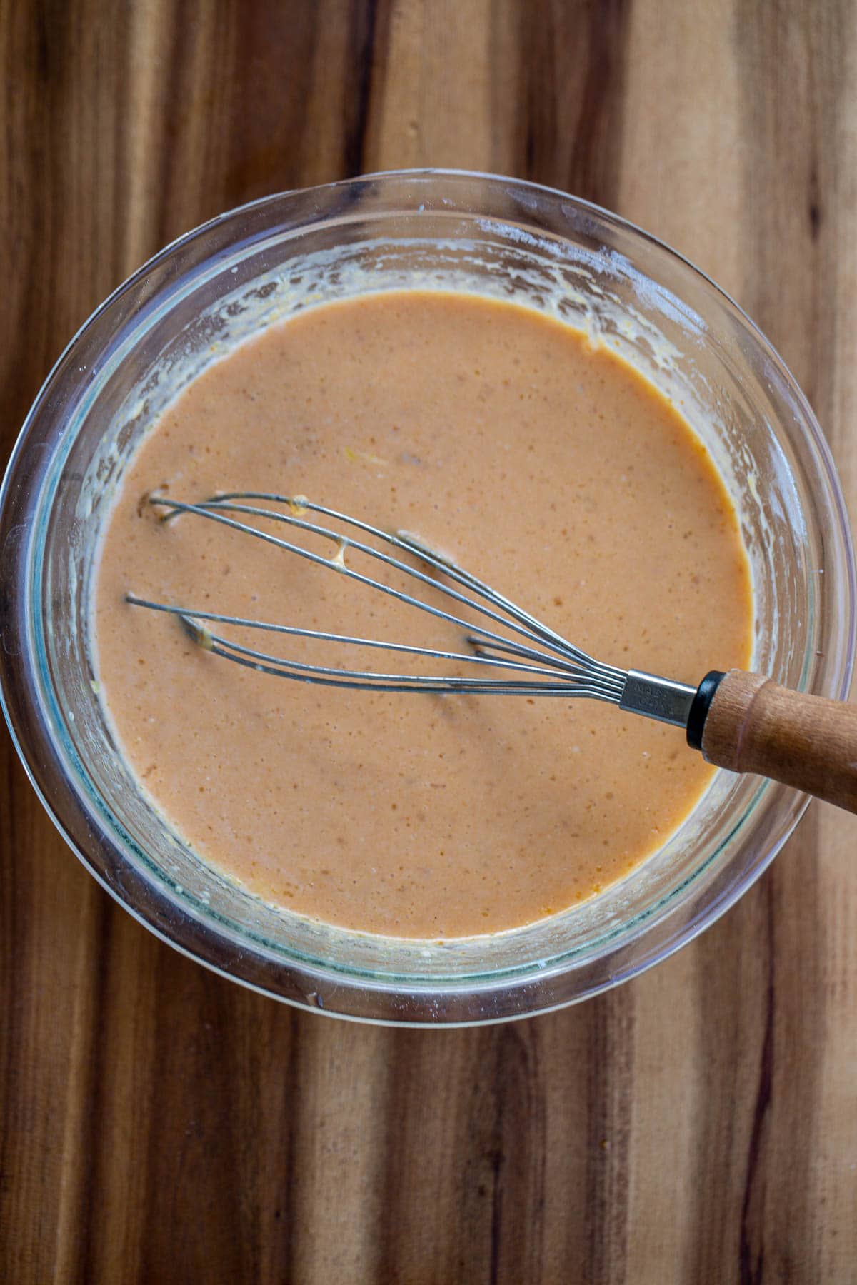 A bowl with eggs, milk, pumpkin puree, vanilla extract, and melted butter.