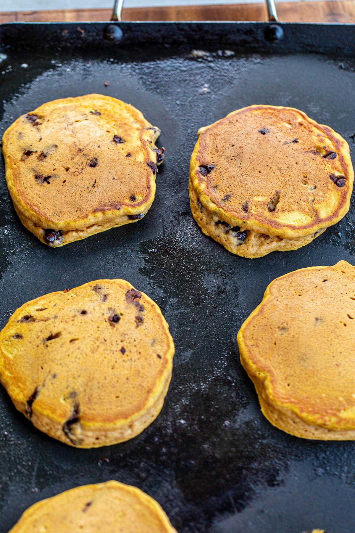 Pancakes cooking on a griddle.