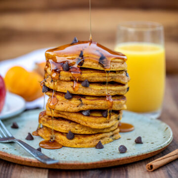 Stack of pumpkin chocolate chip pancakes on a plate.