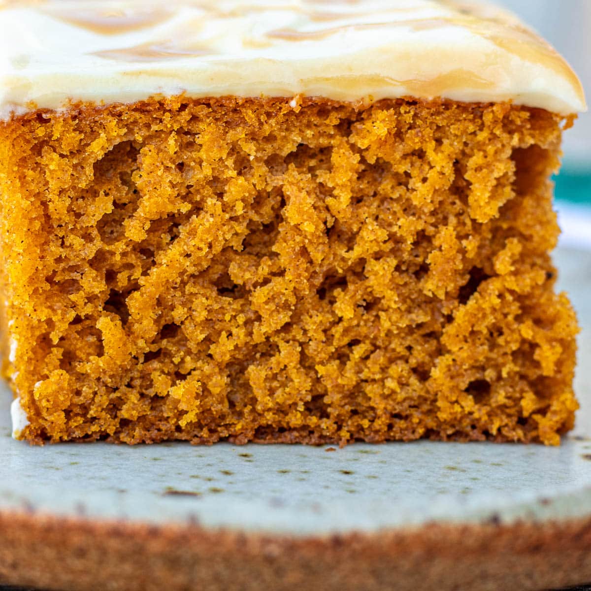 Slice of pumpkin cake with cream cheese frosting.