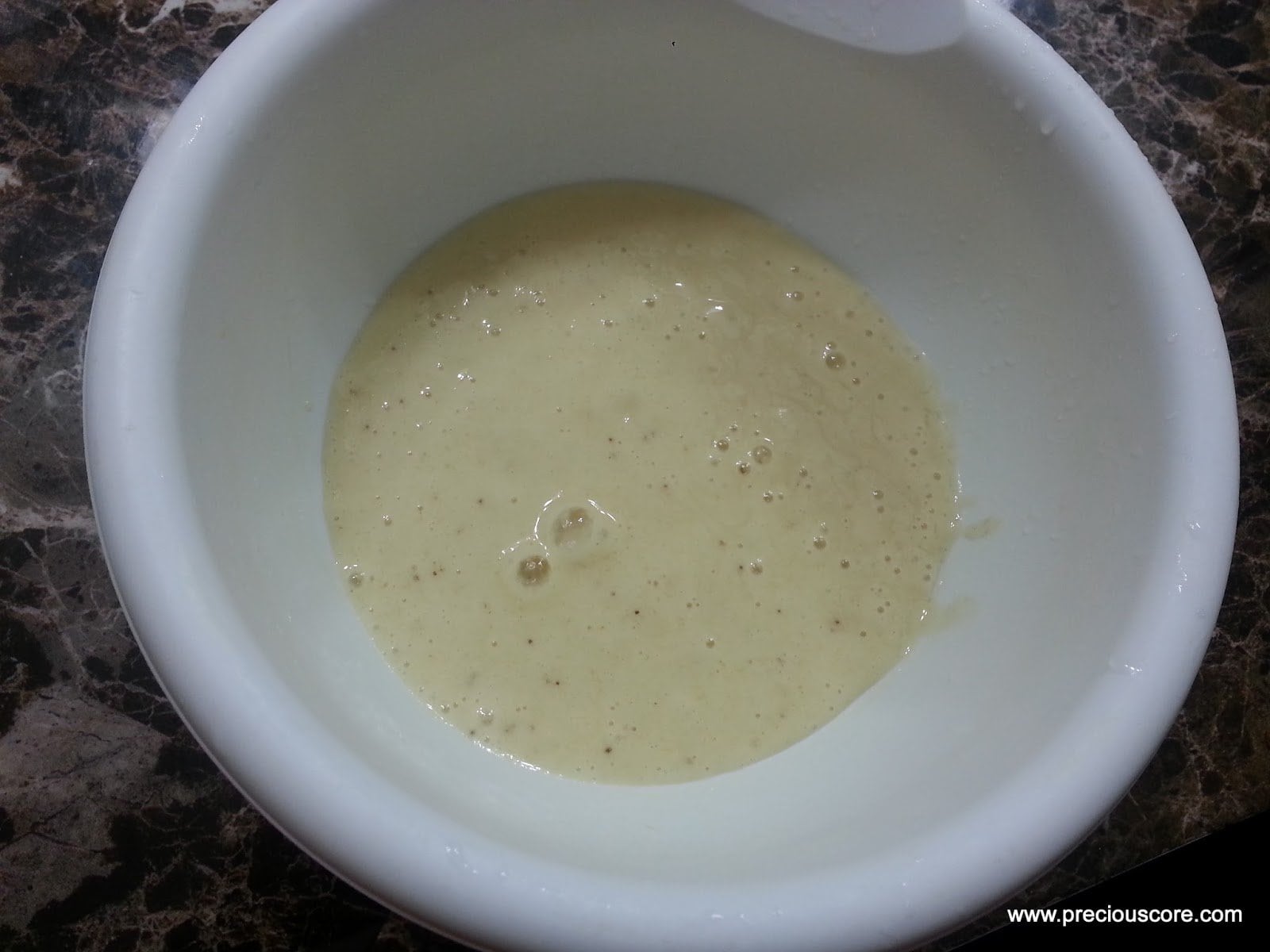 Banana and liquid in a mixing bowl.