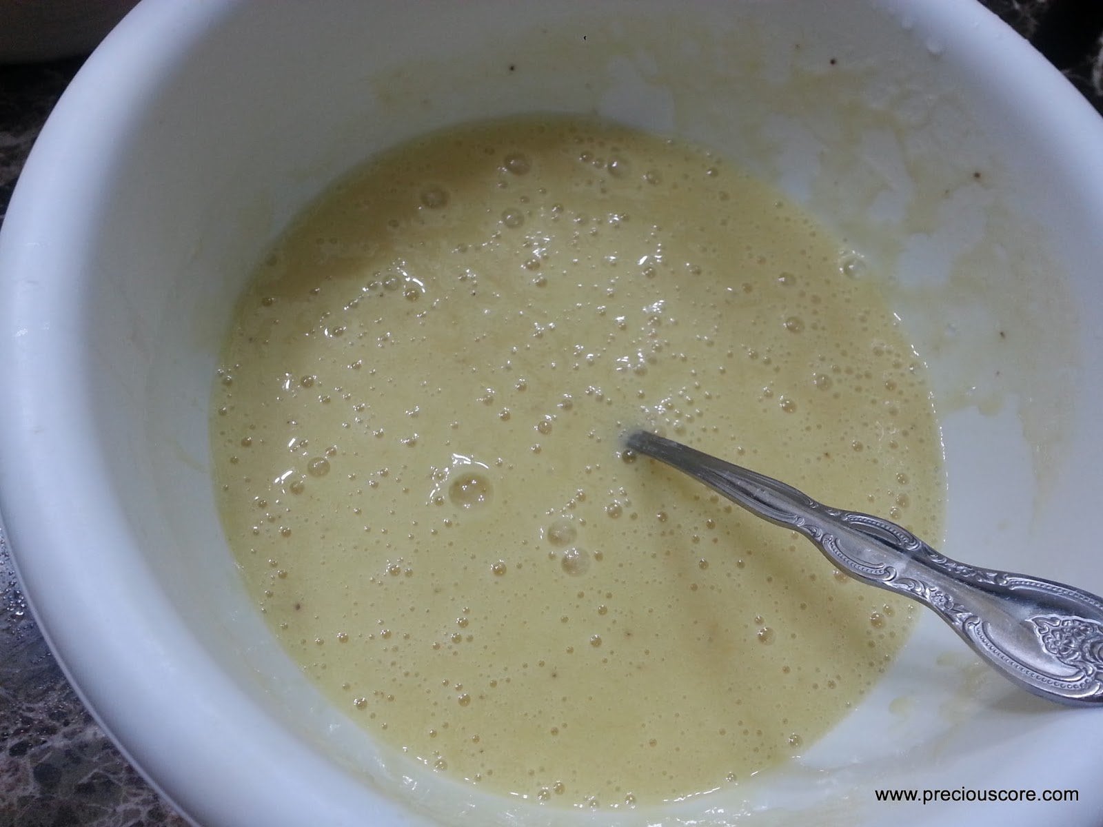 Spoon in a mixing bowl of wet ingredients.