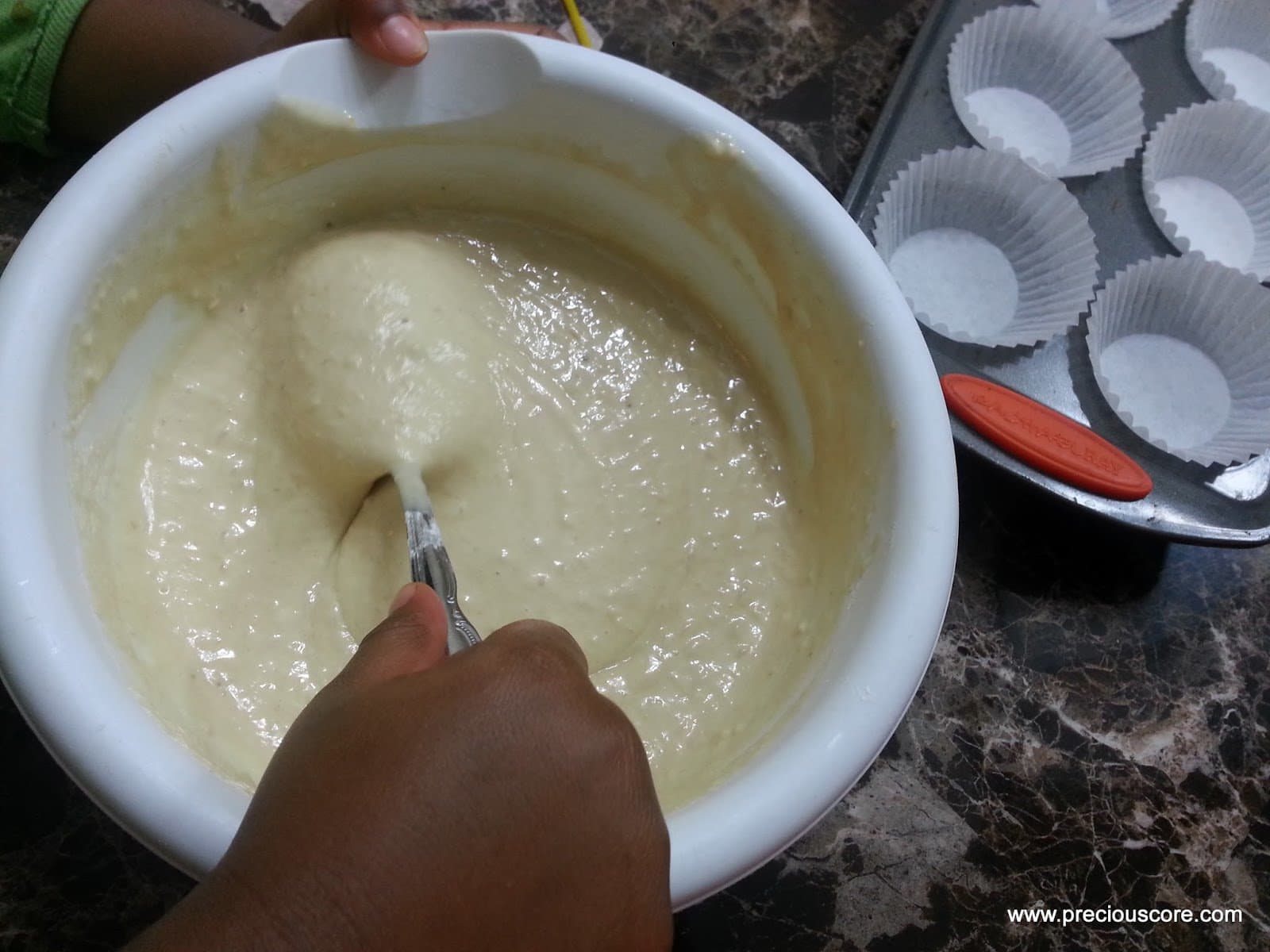 Spoon stirring a bowl of batter.