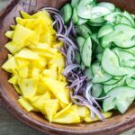 Sliced cucumber, mango and onion in a bowl